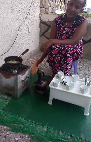 CoffeeInEthiopiaStrandlines Traditional coffee ceremony in Ethiopia - raw coffee beans on the coffee roaster pan sitting on the charcoal container.