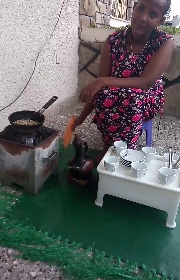 Traditional coffee ceremony in Ethiopia - raw coffee beans on the coffee roaster pan sitting on the charcoal container.