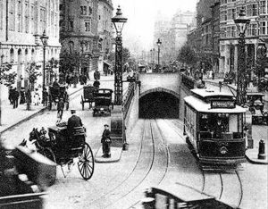 A tram exiting Kingsway Tram Tunnel onto the heavily-trafficked street above.